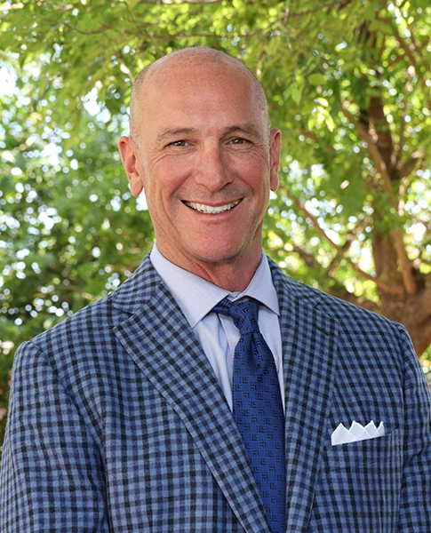 Attorney Dan Davis smiling in a blue plaid suit